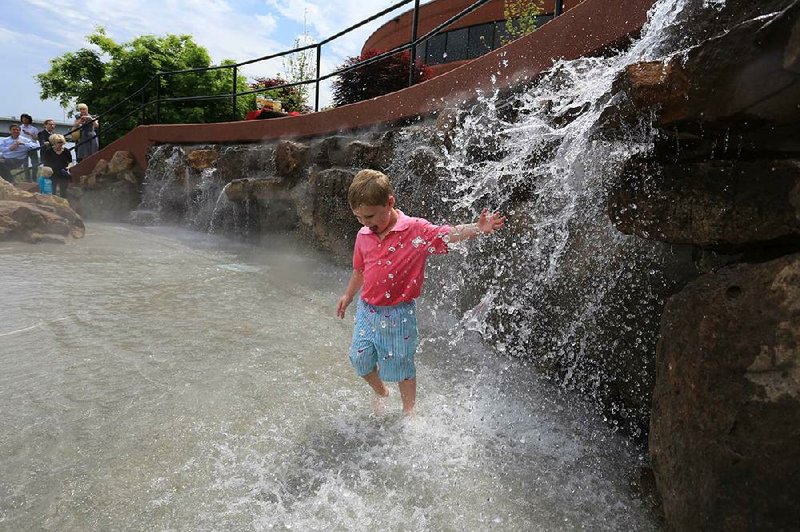 Ben Hunt, 4, of Little Rock, plays in the new splash pad in Little Rock’s Riverfront Park on Thursday during a dedication ceremony for the pad, which is located behind the Little Rock Marriot hotel. 