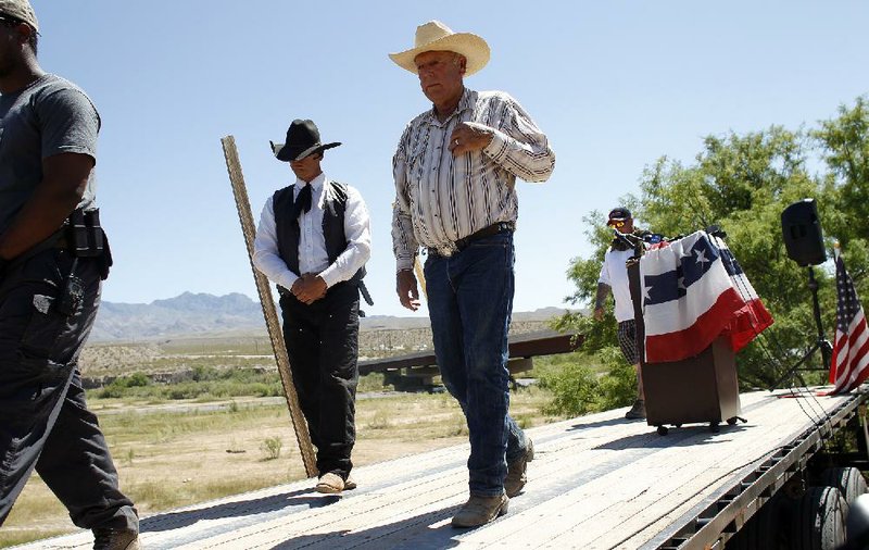 Rancher Cliven Bundy leaves the stage after a news conference Thursday near Bunkerville, Nev., during which he again said he wondered if blacks were “better off” as slaves. 