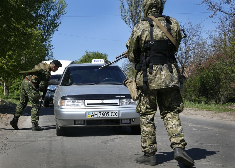 Armed Pro Russian militants inspect a car near Slovyansk, eastern Ukraine, on Friday, April 25, 2014. Russian Foreign Minister Sergey Lavrov has accused the West of plotting to control Ukraine and said the pro-Russian insurgents in the southeast would lay down their arms only if the Ukrainian government clears out the Maidan protest camp in the capital, Kiev. 