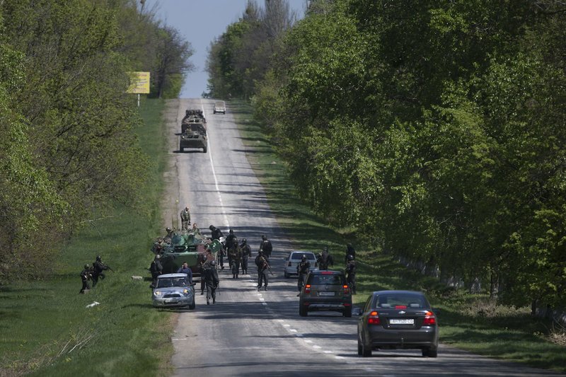 Ukrainian government troops around their armored personal carriers stand guard on a country road outside the town of Svyitohirsk near Slovyansk, eastern Ukraine, Saturday. Ukrainian authorities are undertaking a security operation to liberate the nearby city of Slovyansk, which is currently controlled by an armed pro-Russian insurgency.