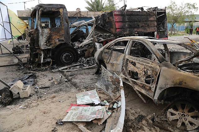 Burned vehicles litter a stadium area in Baghdad on Saturday after Friday’s bomb attack on a Shiite campaign rally. 