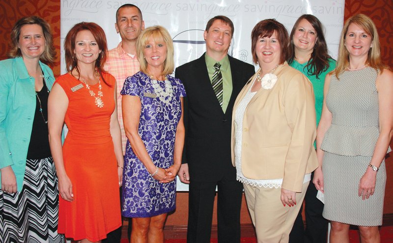 STAFF PHOTOS CARIN SCHOPPMEYER 
Mary McMuth, Butterflies and Blooms guest speaker, from left, stands with Jayci Schmitt, Adam Maass, Jan Shinall, Kent and Becky Shaffer, Brittney Duke and Yvonne Ley, Saving Grace board members, at the group’s annual benefit luncheon April 17 at the John Q. Hammons Center in Rogers.