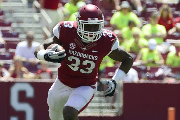 Arkansas running back Korliss Marshall (33) runs the ball during their spring NCAA college football game, Saturday, April 26, 2014, in Fayetteville, Ark. (AP Photo/Sarah Bentham)