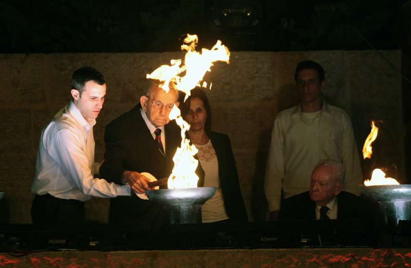 Holocaust survivor Tzvi Michaeli and his grandson light a torch during  the opening ceremony of the Holocaust Remembrance Day at the Yad Vashem Holocaust Memorial in Jerusalem  Jerusalem, Sunday, April, 27, 2014. Israel's annual memorial day for the 6 million Jews killed in the Holocaust has begun with a ceremony marking 70 years since the Warsaw ghetto uprising. (AP Photo/Dan Balilty)