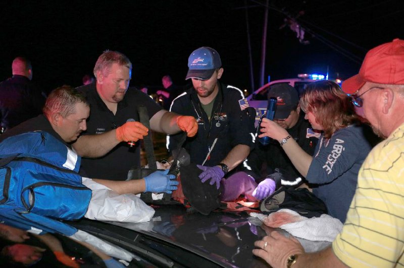 Arkansas Democrat-Gazette/RICK MCFARLAND --04/27/14--  People in Vilonia make their way to shelter after a tornado hit the area Sunday evening. A baby is treated at the triage on Hwy 64.