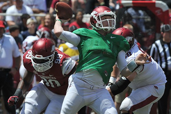 Arkansas quarterback Austin Allen passes the ball while being rushed by defensive end Brandon Lewis (99) during Saturday's Red-White Game at Razorback Stadium in Fayetteville. 