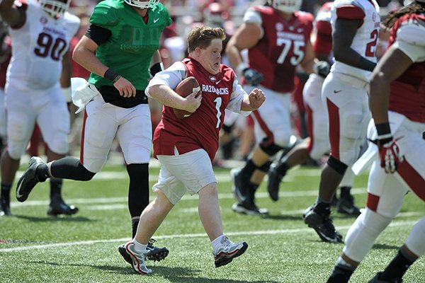 Lifelong Arkansas Razorbacks fan Canaan Sandy runs the ball for a touchdown Saturday afternoon during the Red-White Game at Razorback Stadium in Fayetteville. 