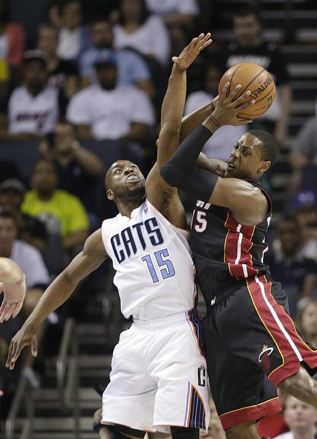 Miami Heat's Mario Chalmers, right, shoots over Charlotte Bobcats' Kemba Walker, left, during the first half in Game 4 of an opening-round NBA basketball playoff series in Charlotte, N.C., Monday, April 28, 2014. (AP Photo/Chuck Burton)
