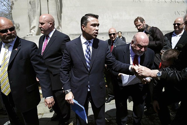 U.S. Rep. Michael Grimm, center, greets supporters as he leaves a news conference outside federal court in New York, Monday, April 28, 2014. The Staten Island Republican was arrested earlier in the day and pleaded not guilty to a 20-count federal indictment that includes charges of mail fraud, wire fraud and tax fraud. (AP Photo/Seth Wenig)