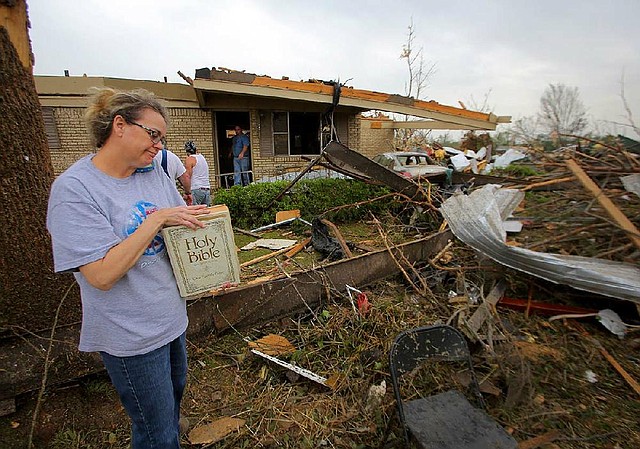 4/28/14
Arkansas Democrat-Gazette/STEPHEN B. THORNTON
Laura Ward cradles her parent's family Bible as she tries to reach her pastor through sporadic cellular phone service outside their  nearly destroyed home along Hwy 365 in Mayflower Monday. Four family members rode out Sunday night's storm in the home with no major injuries. 