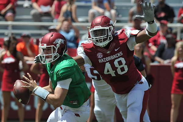 Arkansas defender Deatrich Wise Jr. puts pressure on quarterback Rafe Peavey during the Red-White game Saturday afternoon at Razorback Stadium in Fayetteville.