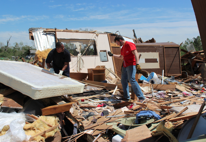 James Guiden, left, works with a volunteer to salvage items from his Mayflower home, which was destroyed in a tornado Sunday night.