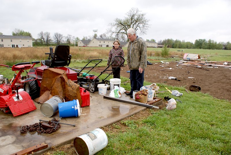 Photo by Dodie Evans Rev. Jack Deaton and his granddaughter, Mikya, survey the wind damage at the Deaton home following Thursday&#8217;s storm. SONY DSC