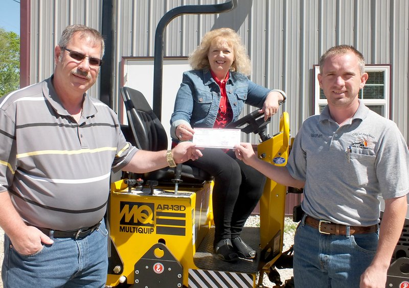 TIMES photograph by Annette Beard State Representative Sue Scott presented $25,000 to Pea Ridge Mayor Jackie Crabtree and Nathan See, street superintendent, to purchase a new vibratory roller and a trailer to transport the roller.