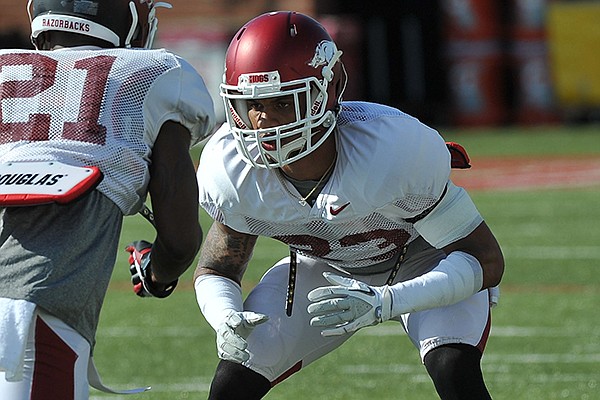 Arkansas cornerbacks Tevin Mitchel (23) and Carroll Washington (21) run drills during practice Thursday afternoon in Fayetteville.