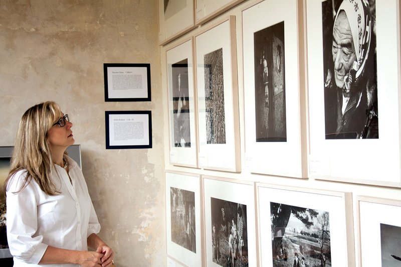 Mary Neilson, director of the Hot Springs Sister City program, looks at some of the photographs included in the exhibition Tohoku: Through the Eyes of Japanese Photographers now on display at Emergent Arts on Whittington Avenue. The photographs, taken from the 1940s to 2012, show life in Tohoku, a region of Japan that includes the Hot Springs Sister City of Hanamaki.