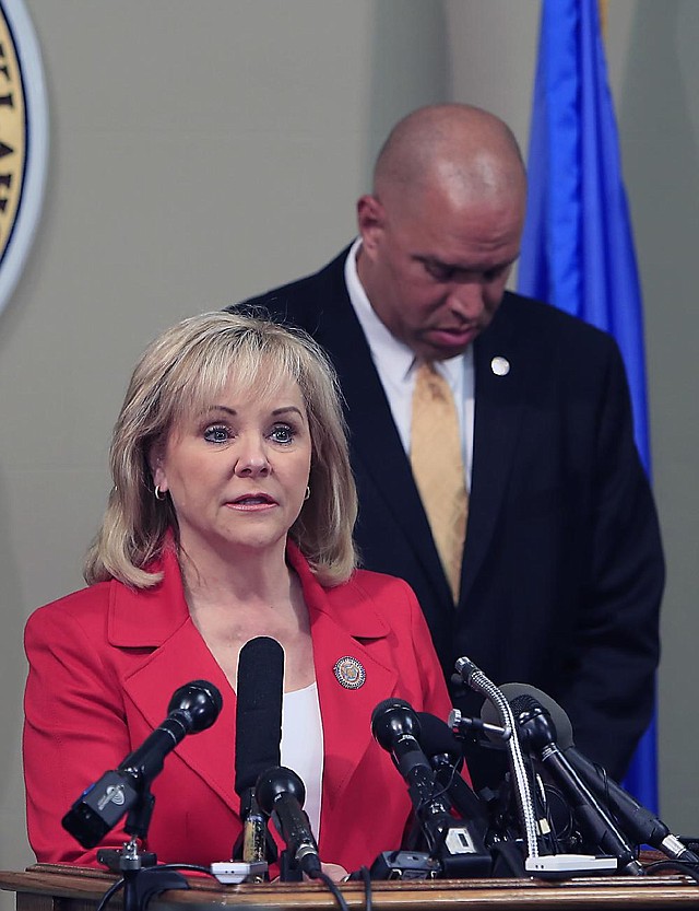 Oklahoma Gov. Mary Fallin announced Wednesday that Department of Public Safety Commissioner Michael Thompson (background) would head a review of execution procedures. 
