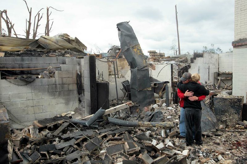 Josh Hunt and his sister-in-law Jessica Hunt embrace Wednesday in the ruin of her home on Dam Road in Mayflower. They recounted escaping from a fire that sent flames and smoke into the 3-by-12 space where they and 14 relatives and neighbors were weathering Sunday’s tornado. 