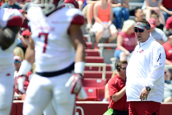 Arkansas head coach Bret Bielema, back center, observes his players on the field during their spring NCAA college football game, Saturday, April 26, 2014, in Fayetteville, Ark. (AP Photo/Sarah Bentham)