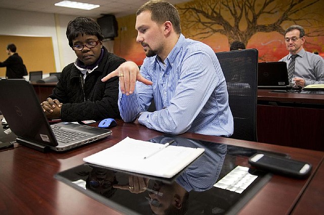 Insurance marketplace guide Chris Casazza helps Johanne Jean Louis sign up for health insurance under the Patient Protection and Affordable Care Act in Milford, Del., in late March. 