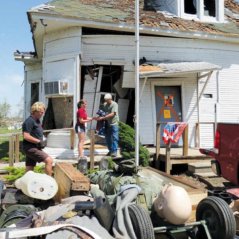 Lucy Bone of Vilonia, left, her daughter Brittany Bone, also of Vilonia, and Paul Hicks of Conway salvage items from the Museum of Veterans and Military History in Vilonia, which was damaged in the tornado a week ago today. Linda Hicks, museum founder, said the building was set to be torn down.