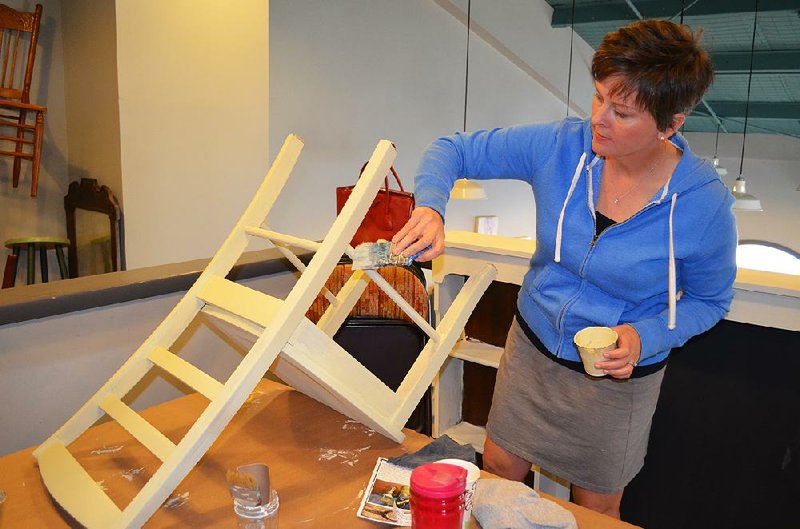 Karen Carter paints a chair at Reinvented Vintage in Little Rock during a painting workshop at the store. 