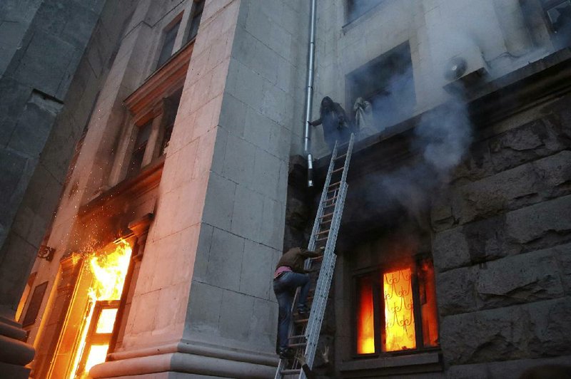 People wait to be rescued as a fire rages Friday at the trade-union building in Odessa, Ukraine. Officials gave no details about how the fire started, but clashes broke out in the port city between pro-Russian and government supporters. 
