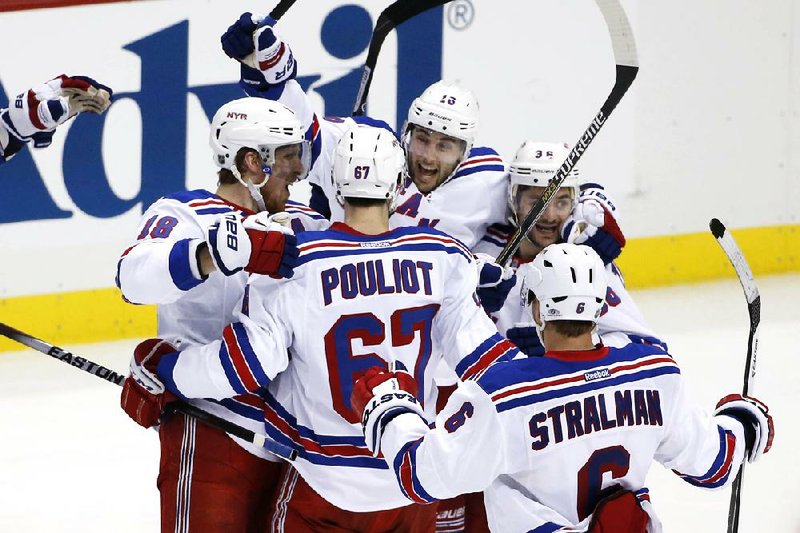 New York Rangers' Derick Brassard (16) celebrates his game-winning goal with teammates in the first overtime period of Game 1 of a second-round NHL hockey playoff series against the Pittsburgh Penguins in Pittsburgh, Friday, May 2, 2014. The Rangers won 3-2. (AP Photo/Gene J. Puskar)
