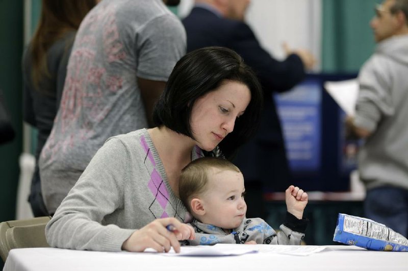Sarah Keegan of Windham, N.Y., with her son Kevin in her lap, fills out paperwork during an April 22 job fair at Columbia-Greene Community College in Hudson, N.Y. The Labor Department reported Friday that U.S. employers added 288,000 jobs in April, the most in two years. 