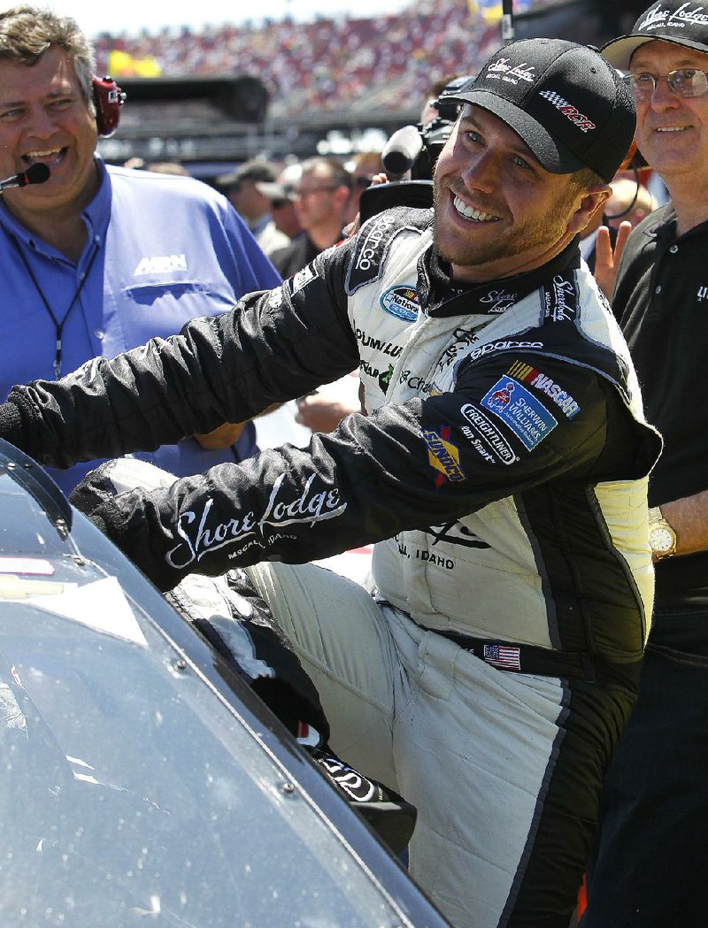 Brian Scott climbs from his car Saturday after winning the pole for today’s NASCAR Sprint Cup Aaron’s 499 at Talladega (Ala.) Superspeedway. 