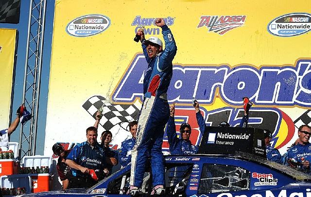 Elliott Sadler celebrates after winning Saturday’s NASCAR Nationwide Series race at Talladega (Ala.) Superspeedway as his crew chief, Little Rock native Chris Gayle (lower left), looks on. It was Gayle’s first victory as a NASCAR crew chief. 