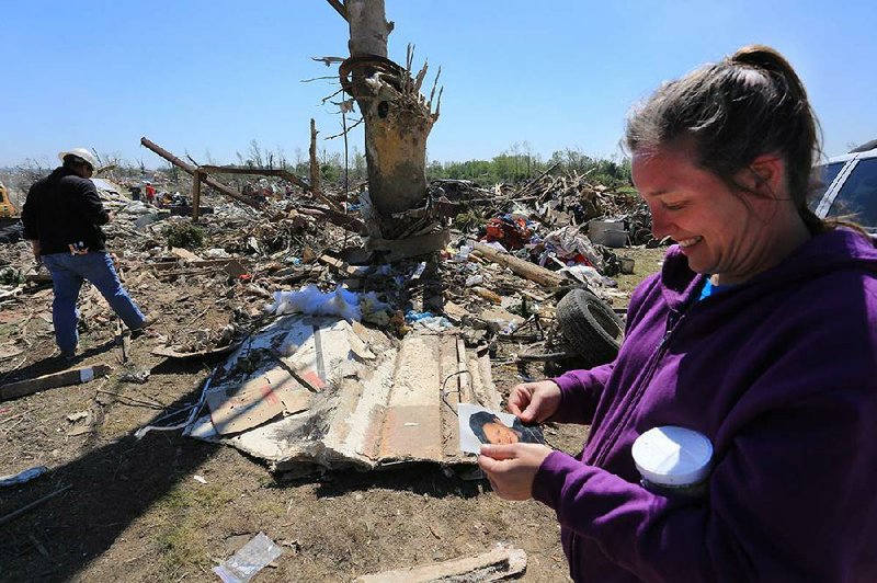 Melissa Bradley gazes at a picture of her son Tyler, now 20, that a volunteer found Thursday in the debris of Bradley’s home on Cemetery Road in Vilonia. 