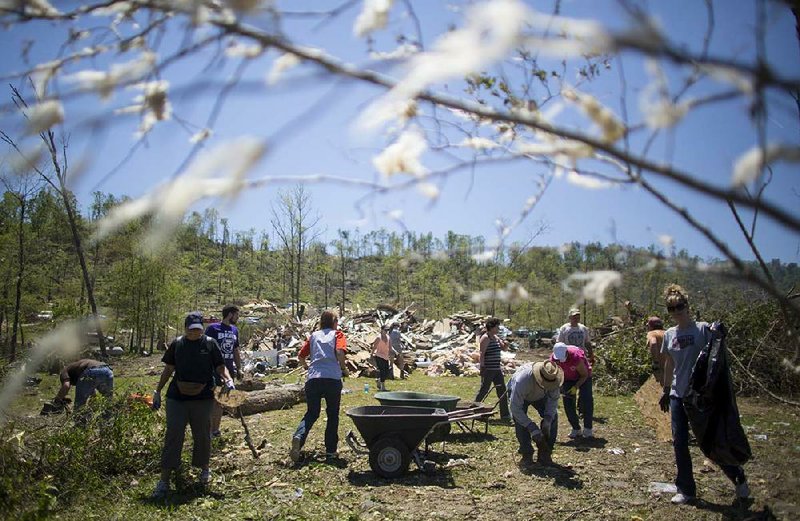 Volunteers work Saturday cleaning up at the tornado-hit home of Lance Hobday and his family on Deer Drive near Paron. 