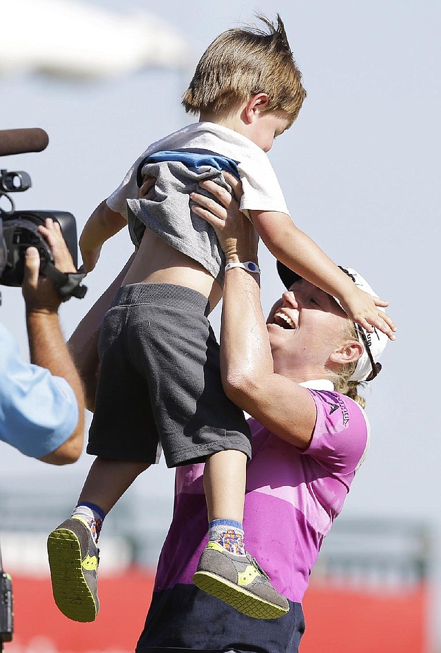 Stacey Lewis lifts her nephew Cole Wysocki, 3, after winning the North Texas LPGA Shootout golf tournament at Las Colinas Country Club in Irving, Texas, Sunday, May 4, 2014. (AP Photo/LM Otero)