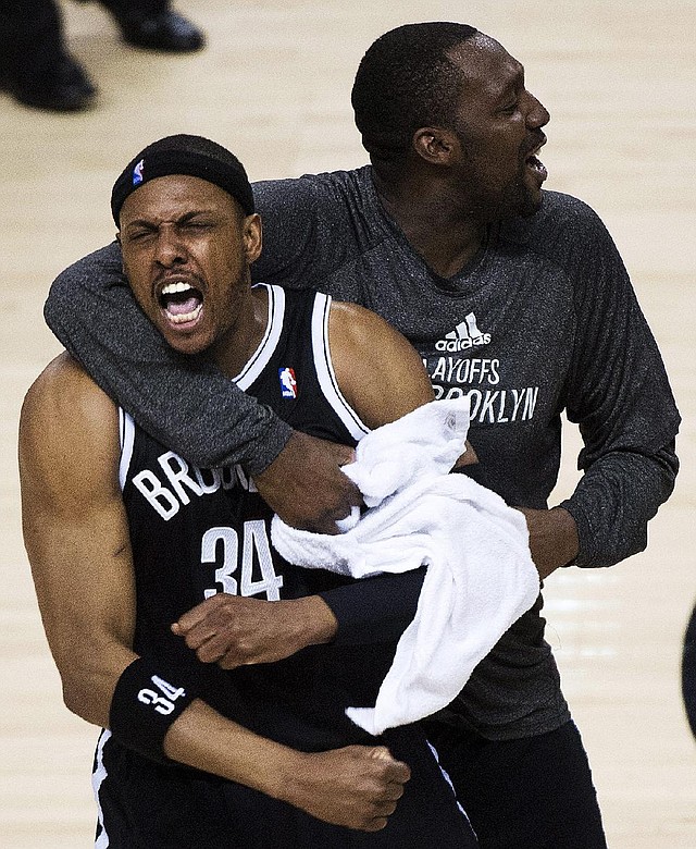 Brooklyn Nets forward Paul Pierce (34) reacts with teammate Andray Blatche, right, after defeating the Toronto Raptors in Game 7 of the opening-round NBA basketball playoff series in Toronto, Sunday, May 4, 2014. (AP Photo/The Canadian Press, Nathan Denette)