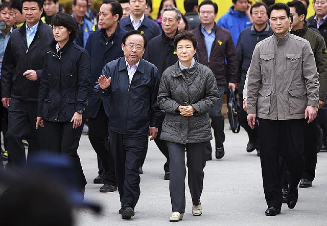 South Korean President Park Geun-hye, center right, is escorted by Oceans and Fisheries Minister Lee Ju-young to meet with relatives of passengers aboard the sunken ferry Sewol at a port in Jindo, South Korea, Sunday, May 4, 2014. Divers battled strong currents and wind Saturday to search unopened rooms in the sunken South Korean ferry for dozens of missing passengers, officials said Saturday. (AP Photo/Yonhap) KOREA OUT