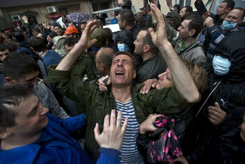 A man cries after being released from a local police station which was stormed by pro-Russian protesters in Odessa, Ukraine, Sunday, May 4, 2014. Several prisoners that were detained during clashes that erupted Friday between pro-Russians and government supporters in the key port on the Black Sea coast were released under the pressure of protesters that broke into a local police station and received a hero's welcome by crowds. (AP Photo/Vadim Ghirda)