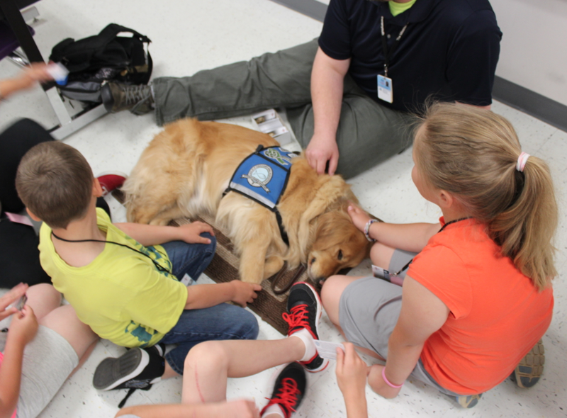 Students at Mayflower Elementary School pet a comfort dog Monday in the first day back at school more than a week after a tornado devastated the Faulkner County city.