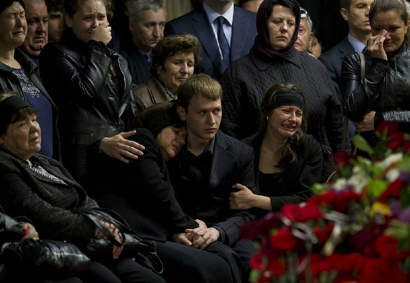 Mourners and family members cry next the coffin of regional parliament member Vyacheslav Markin, in Odessa, Ukraine, Monday, May 5, 2014. Markin, who was known for speaking out against the government in Kiev, was buried as about 300 pro-Russia supporters shouted "Hero, hero!" Markin died Sunday from burns sustained Friday in a fire that followed clashes in Odessa. (AP Photo/Vadim Ghirda)