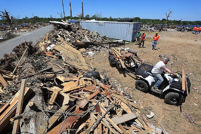 Arkansas Democrat-Gazette/RICK MCFARLAND --05/05/14--   Robert Steinle cq, of Sherwood, pulls a load of debris with a 4-wheeler to be unloaded aside Dam Rd. in Mayflower Monday. An F-4 tornado hit the area April 27.