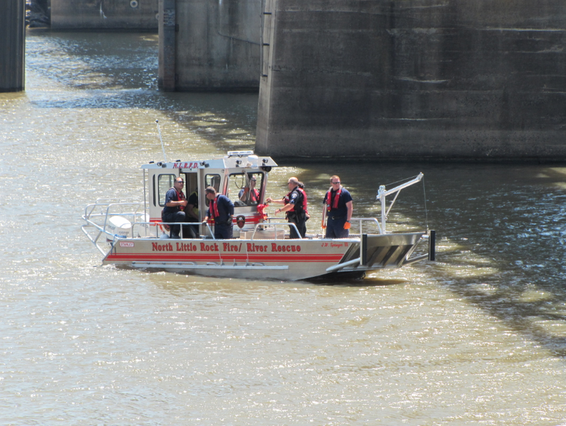 A North Little Rock Fire Department rescue team searches the Arkansas River between the downtown areas of Little Rock and North Little Rock on Tuesday after a witness reported seeing a person jump from the Junction Bridge.