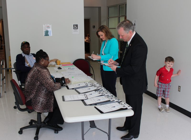 Tim Griffin and his wife, Elizabeth, fill out paperwork to vote early while their son, Jack, waits behind them Tuesday.