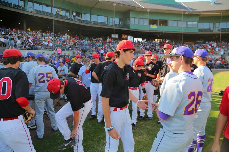 Baseball players from Vilonia and Mayflower high schools gather at home plate before Tuesday’s benefit game at Dickey-Stephens Park in North Little Rock. Both communities were ravaged last week by tornadoes that killed 16 people, most of them in those communities. See more photos at arkansasonline.com/galleries 