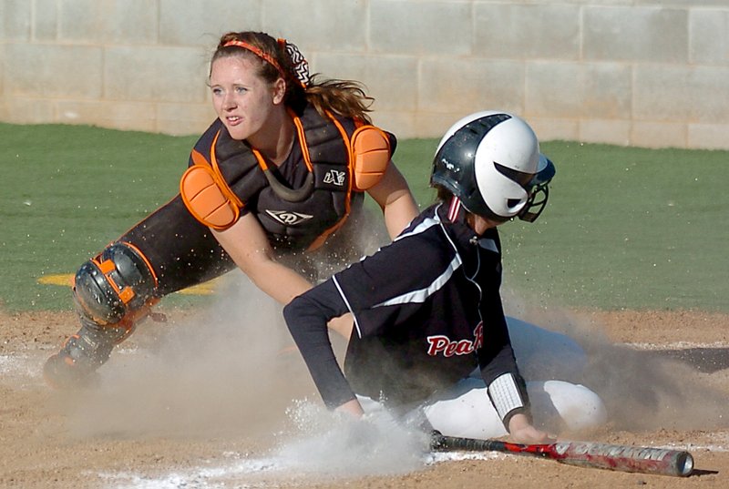 Photo by Randy Moll Gravette catcher, Emily Miller, puts the tag on a Pea Ridge runner sliding into home and looks for another play on the field during tournament play at Prairie Grove on Friday.