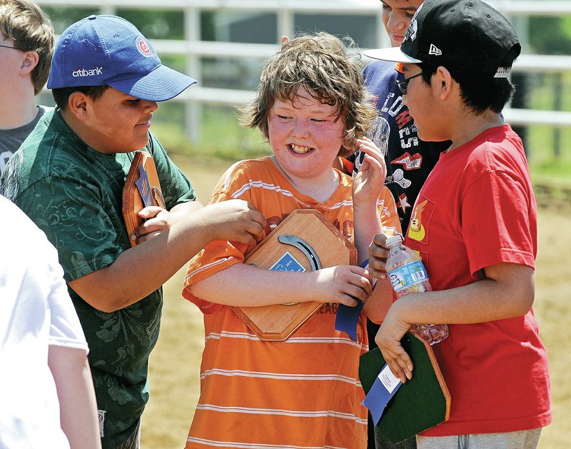 STAFF PHOTO BEN GOFF Marco Tinoco, 10, from left, Leroy Parson, 10, and Roberto Turcios, 11, from Northside, laugh Tuesday after receiving plaques in the annual Special Olympics equestrian event in Bentonville.