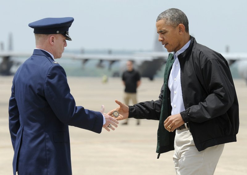 President Barack Obama shakes hands with Col. Patrick Rhatigan, Commander, 19th Airlift Wing & Little Rock AFB, and gives him a challenge coin after Obama arrives at Little Rock Air Force Base on Wednesday, May 7, 2014. Obama is visiting with first responders and families affected by the recent tornadoes. 