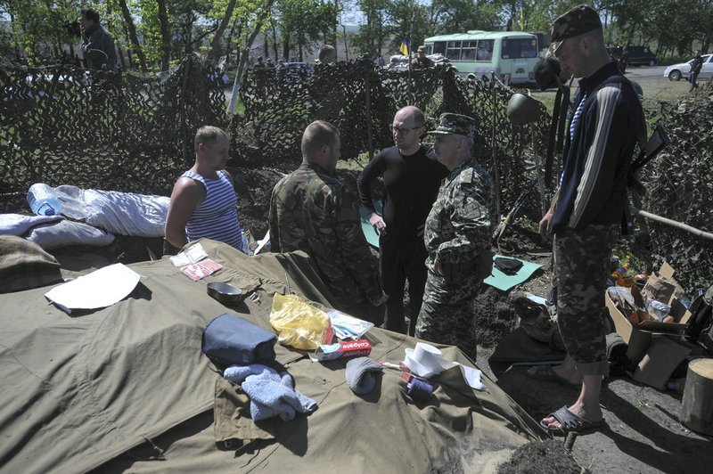 Ukrainian Prime Minister Arseniy Yatsenyuk, centre, talks with Ukrainian soldiers at Slovyansk, Ukraine, Wednesday, May 7, 2014. Russian President Putin on Wednesday announced that Russia has pulled back its troops from the Ukrainian border, and called on Ukraine’s military to halt operations against pro-Russia activists who have seized government buildings and police stations in cities in eastern Ukraine. 