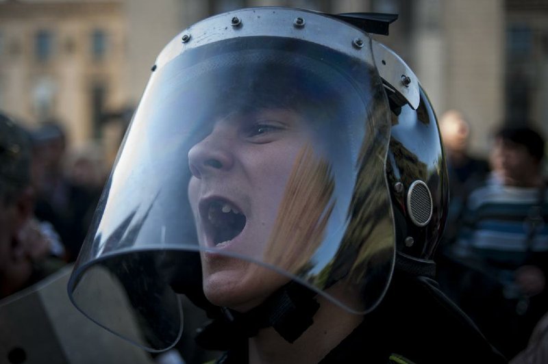 A pro-Russian demonstrator in a police helmet shouts outside the regional interior ministry building Wednesday in Luhansk, eastern Ukraine. 