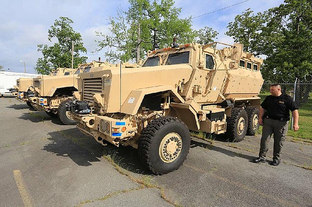 Lt. Carl Minden of the Pulaski County sheriff’s office Wednesday shows off three mine-resistant, ambush-protected vehicles that are being stored in Little Rock for other law enforcement agencies. 