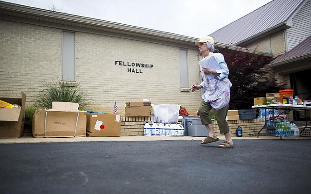 Arkansas Democrat-Gazette/MELISSA SUE GERRITS - 05/08/2014 -  Elizabeth Smith, referred to as Miss Liz, runs through the parking lot to speak with men from Haymarket, Virginia with Park Valley Church Disaster Relief bringing donated supplies for those affected by the April 27th tornado. Smith has become the unofficial coordinator for Pleasant Valley Baptist Church's volunteer hub on Kanis Rd. near Ferndale, Paron, and Little Rock. 